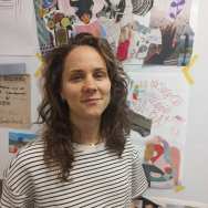 Portret Mieke Seuren met posters op achtergrond