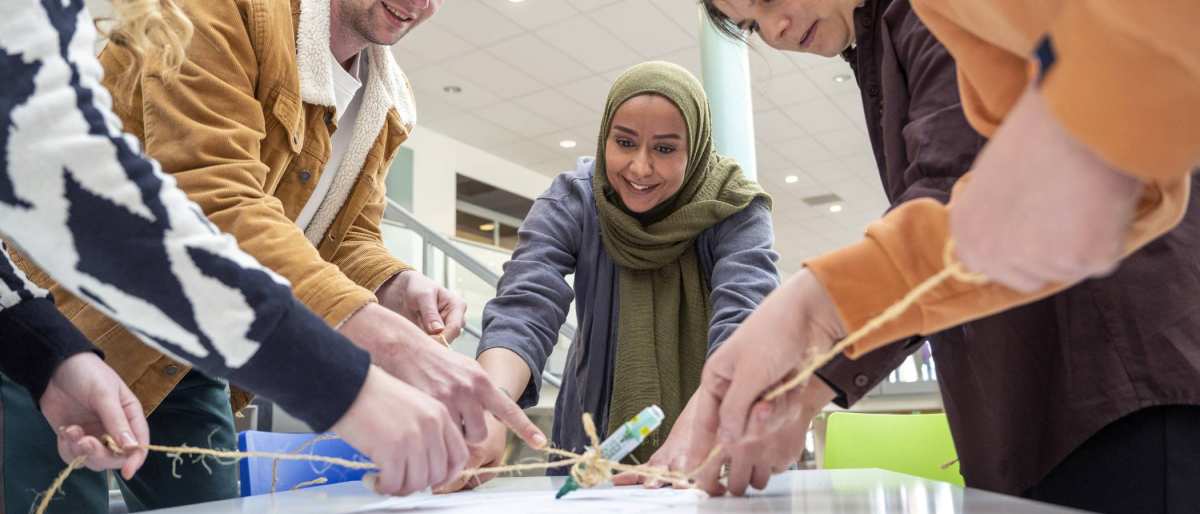 Groep studenten met een docent spelen een spel met een stift. (verzadiging en kleurbalans bewerkt)