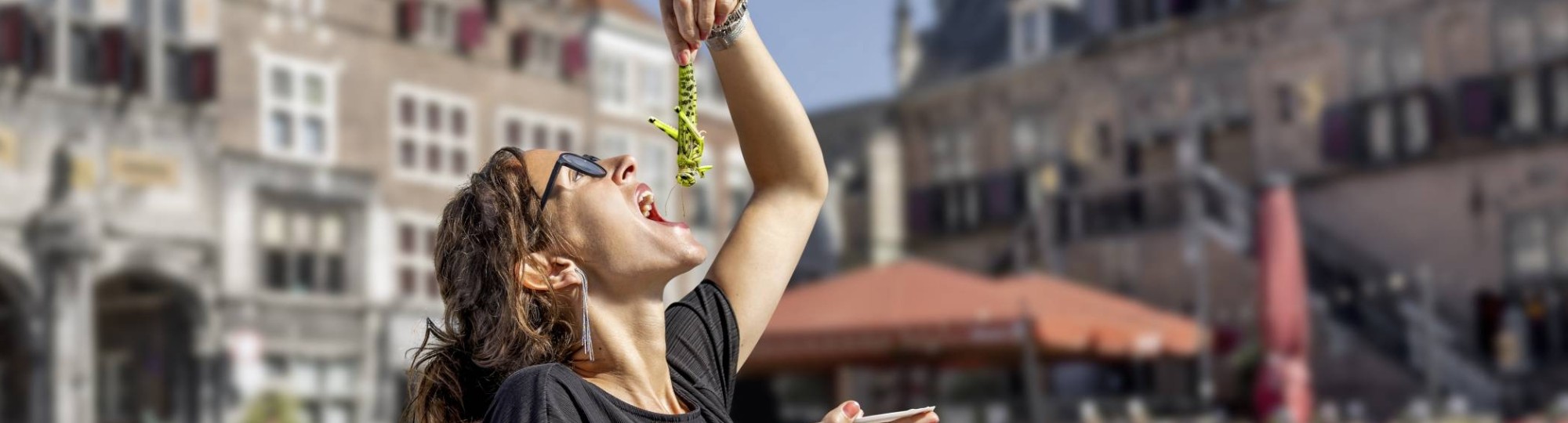 Vrouw eet een krekel alsof het een haring is