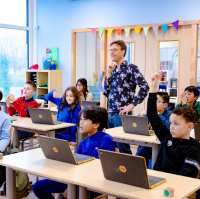 Meester en leerlingen kijken naar het bord