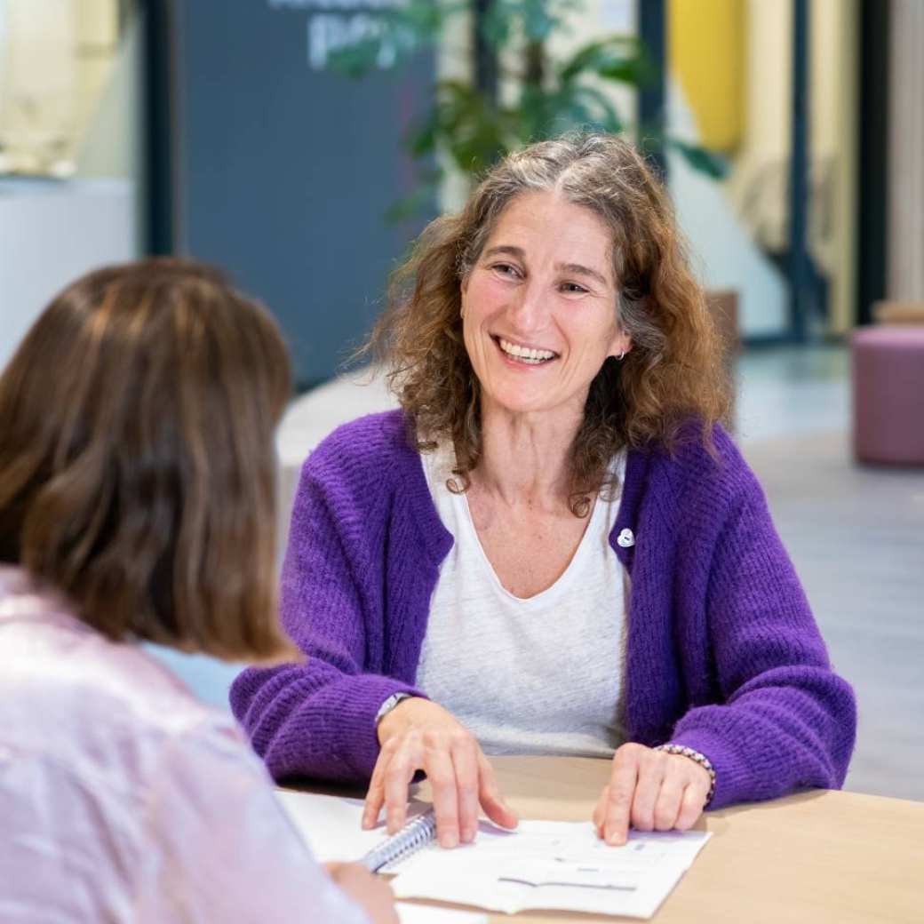 2 studenten aan tafel in gesprek