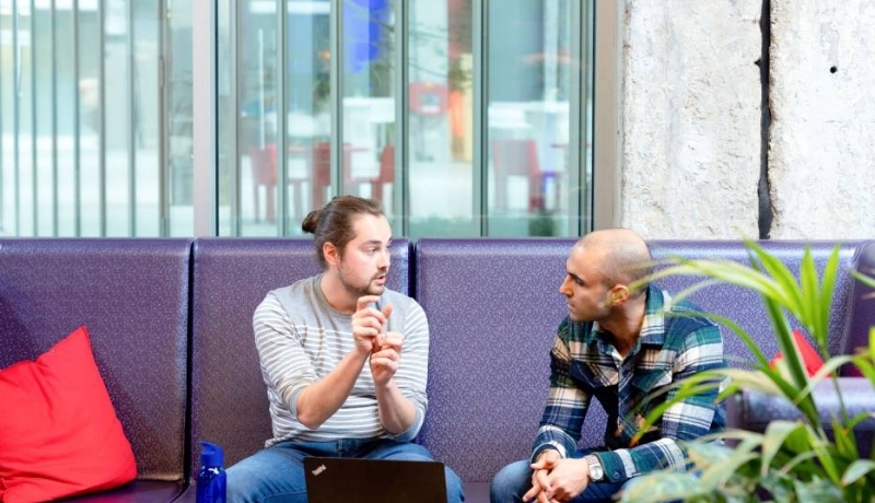 Student geeft handgebarend uitleg met circulaire tafel op voorgrond. Master Circulaire Economie (DT) 2024.