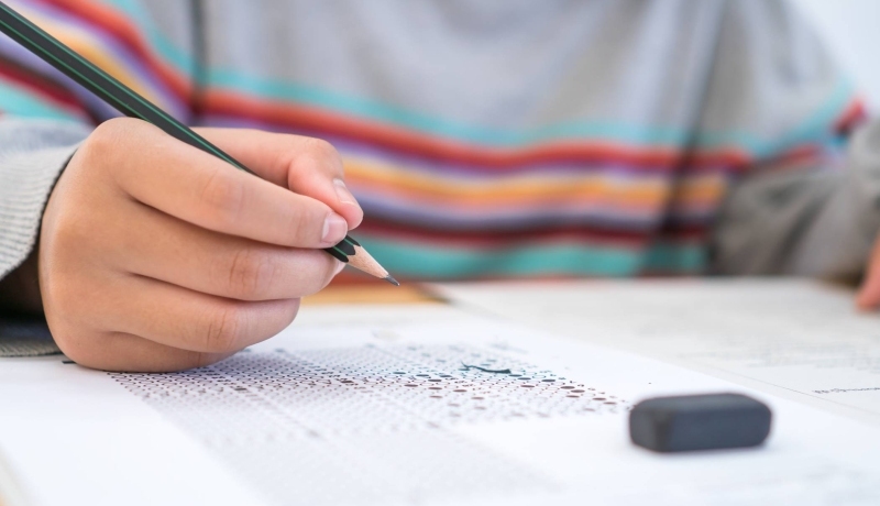 iemand met pen in de hand die examen maakt