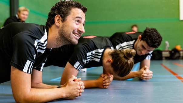 Sportstudenten planken in sportzaal
