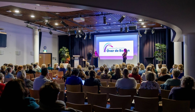 Congreszaal met bezoekers van Over de Bogen