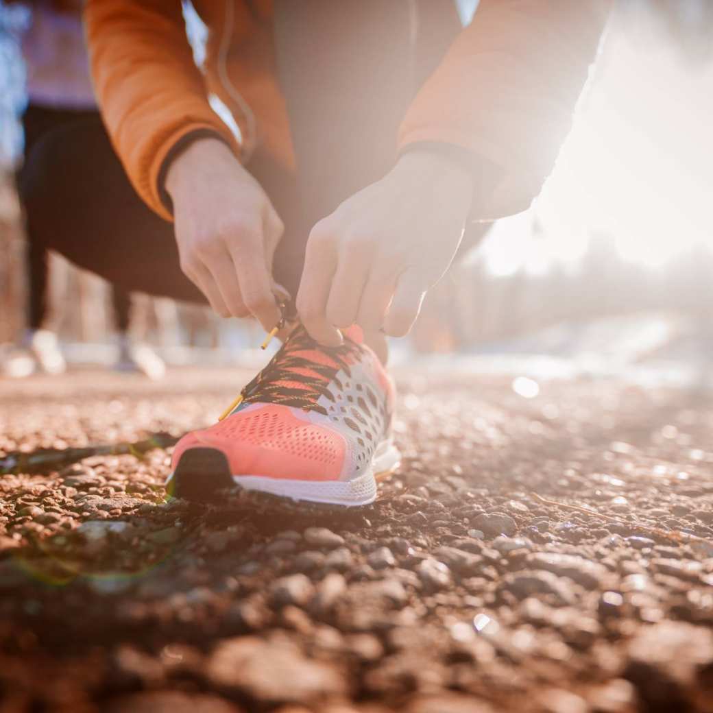 Een hardloopster strikt haar schoenen