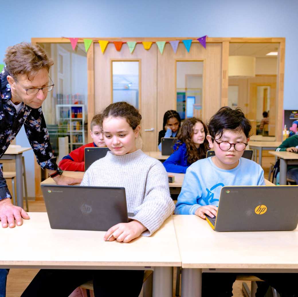 Groep 5,6,7 op de school Da Vince. 
De kinderen werken in de klas achter de laptop. 