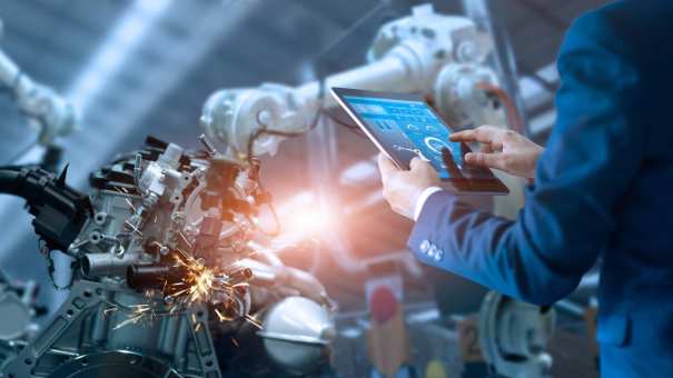 Engineer staat op slimme productievloer met robotarmen