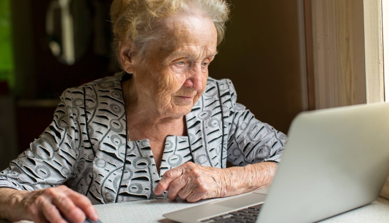 Ouder persoon achter laptop