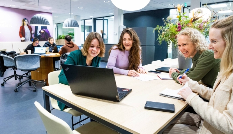 Post-hbo Bedrijfskunde, deelnemers werken samen aan een opdracht met laptop.