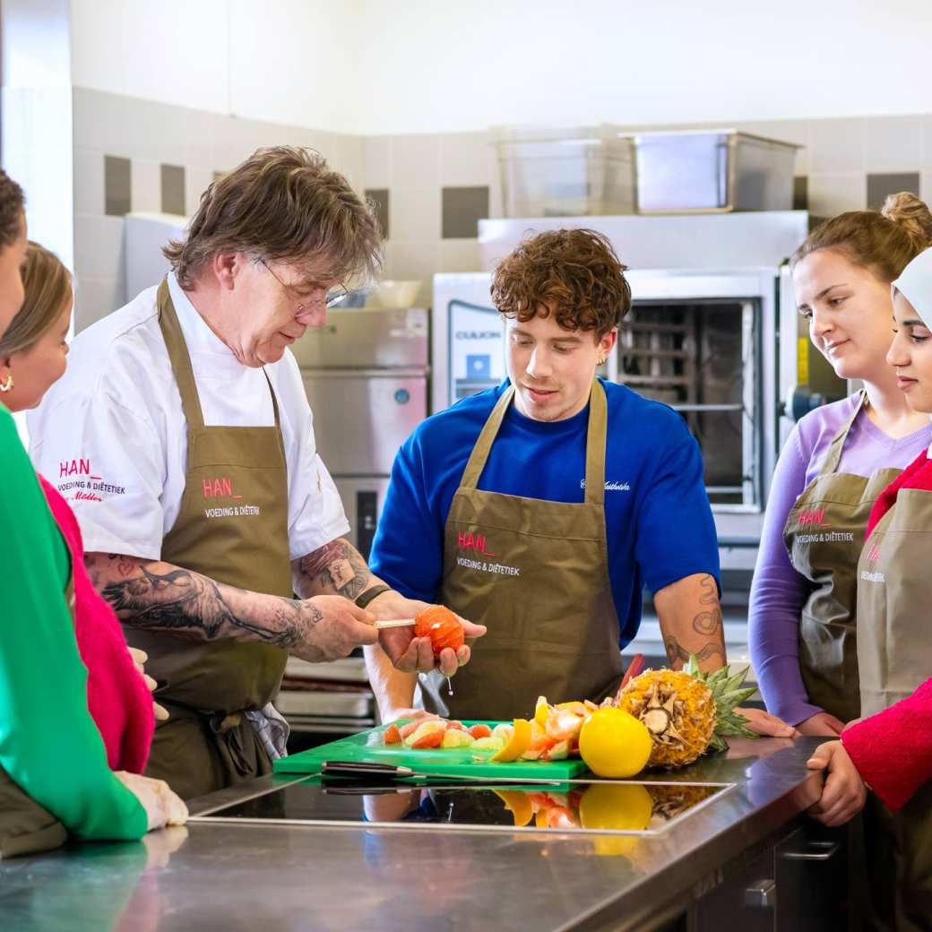 Studenten krijgen instructie in de keuken.