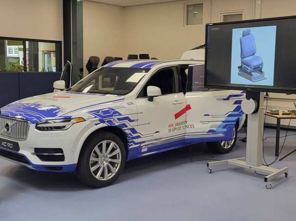 Volvo XC90 die opvallend is gewrapt in een passende lichtblauwe kleurstelling en bijpassend HAN design.
Deze Volvo XC90 wordt o.a. gebruikt voor het project HUBRIS (HUman-like Behaviour of Robotic In-vehicle Systems). Hierin zal de stoel van de bijrijder aangepast worden om als een rijsimulator de passagier het gevoel te geven dat deze echt meerijdt. Met een VR-bril op zal de testpersoon virtueel de A50 van Arnhem naar Apeldoorn (mee)rijden. Soms bestuurt door een normale 'autopilot', soms door een 'robotbestuurder' die meer mensachtig gedrag vertoont.
Het doel is uit te vinden of onze mensachtige robot voor de passagier fijner aanvoelt dan de standaardsystemen.