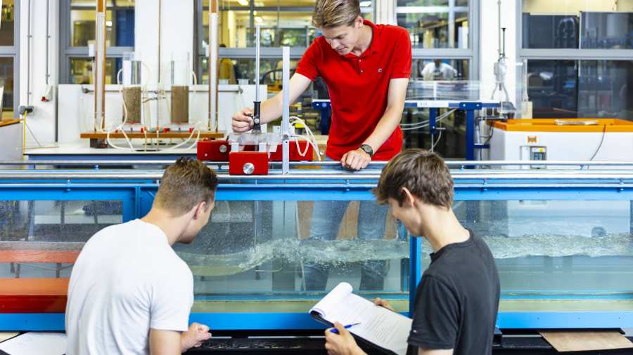 drie studenten simuleren in het waterlab situaties voor civiele techniek waterbouwkunde