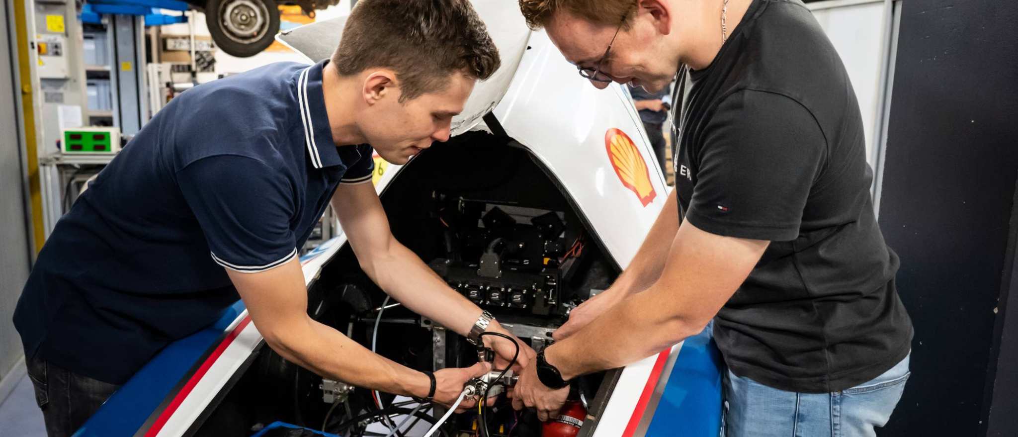 Twee studenten automotive werken samen aan het MH15 voertuig van de HAN.