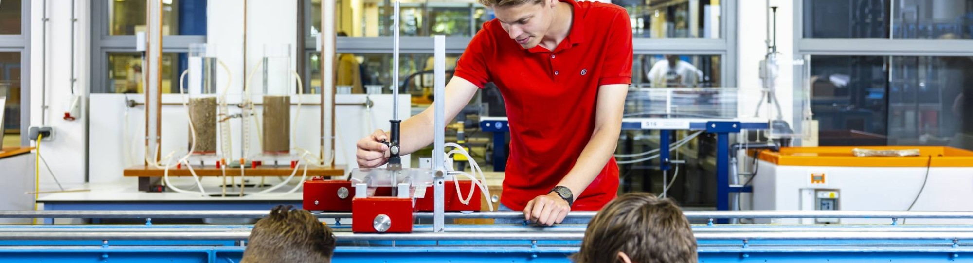 drie studenten simuleren in het waterlab situaties voor civiele techniek waterbouwkunde