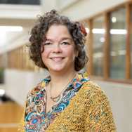 gebloemde blouse, okergeel vest en bloem in haren