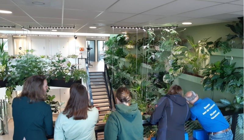 studenten kijken over een reling bij Aeres Hogeschool in Almere om te kijken hoe ze WELL integreerde in het schoolgebouw