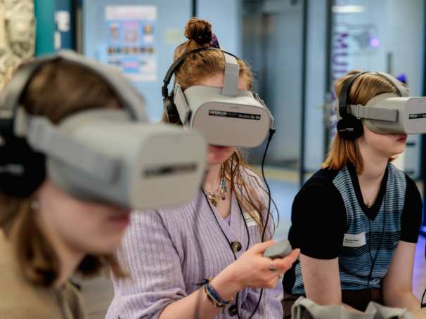 Drie vrouwen met een grijze virtual reality bril op