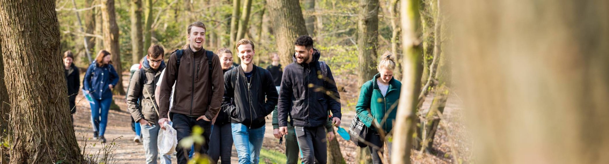 Groep biologie studenten lachend in het bos