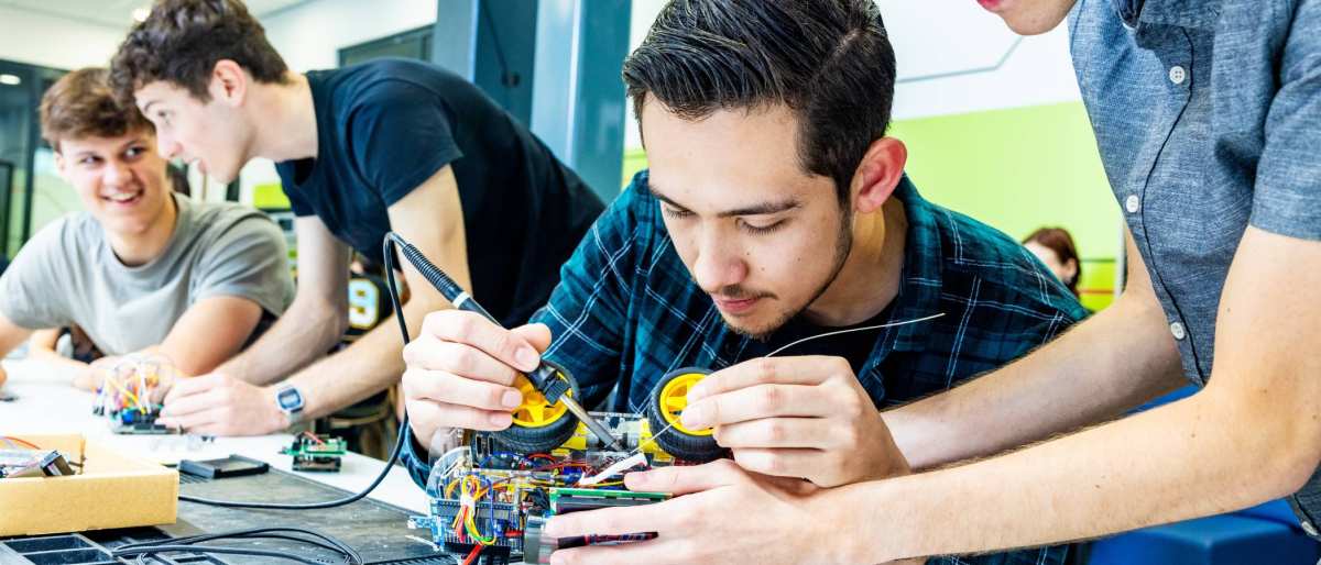 Studenten embedded systems engineering solderen aan programmeerbare auto.