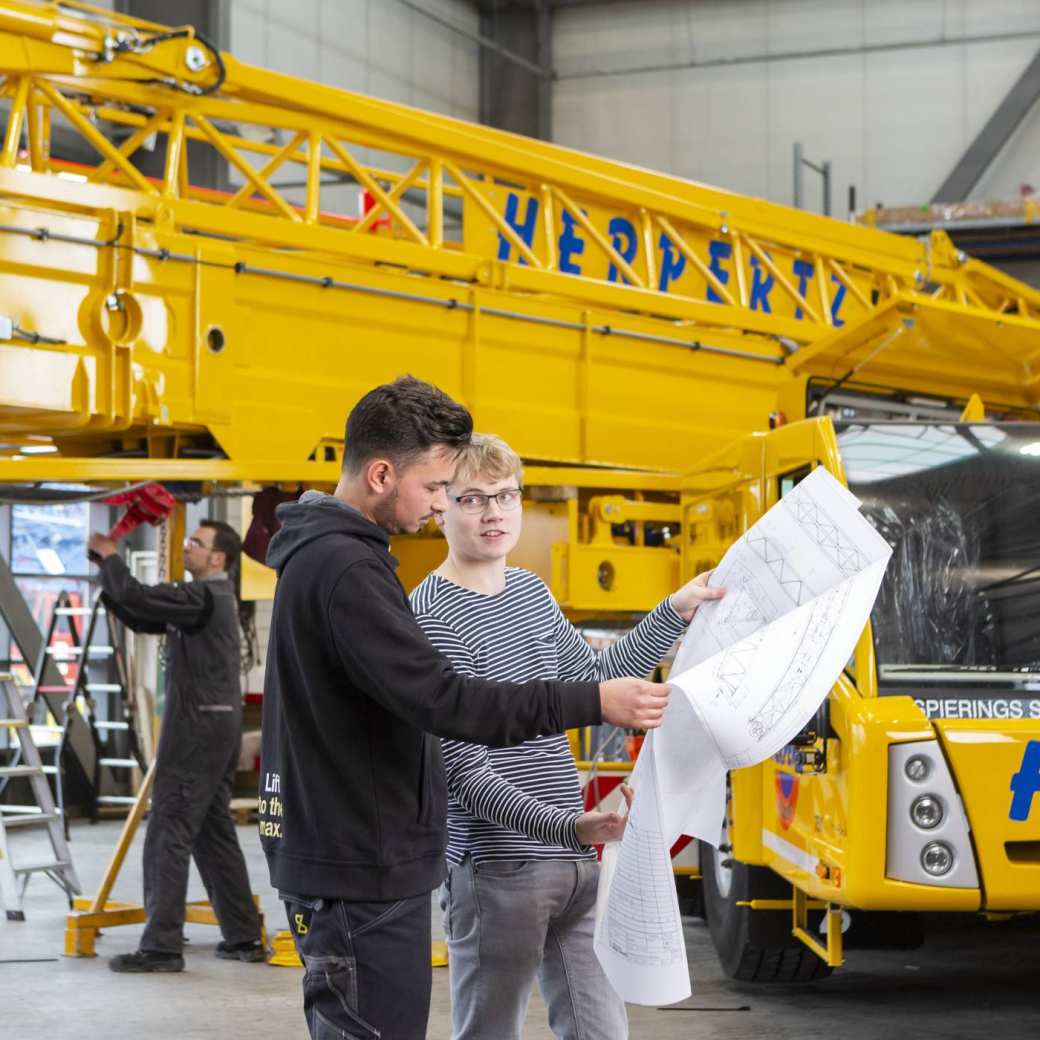Twee studenten van de associate degree Constructeur Werktuigbouwkunde op hun werkplek. Rechtenvrije foto uit de techniekbeeldbank. Academie Engineering en Automotive.