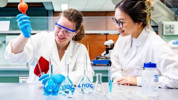 studenten pipetteren in het chemielab