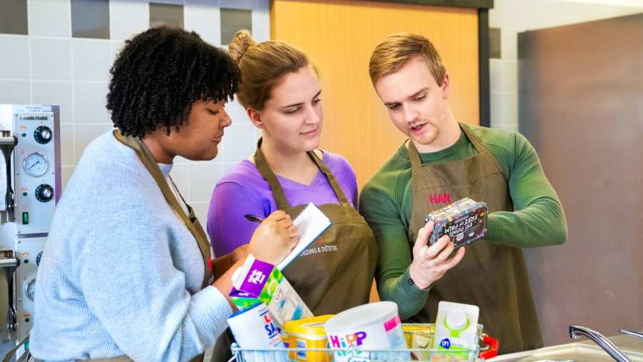 drie studenten voeding en diëtetiek bestuderen etiket van verpakking