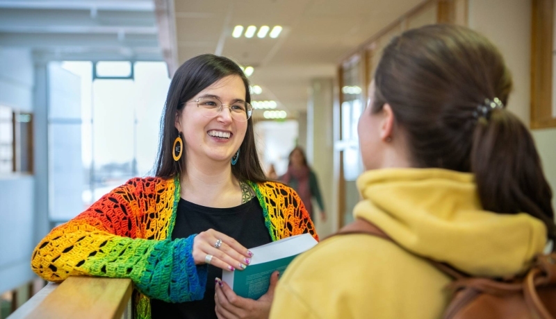 2 masterstudenten Leraar Nederlands met elkaar in gesprek op de gang,