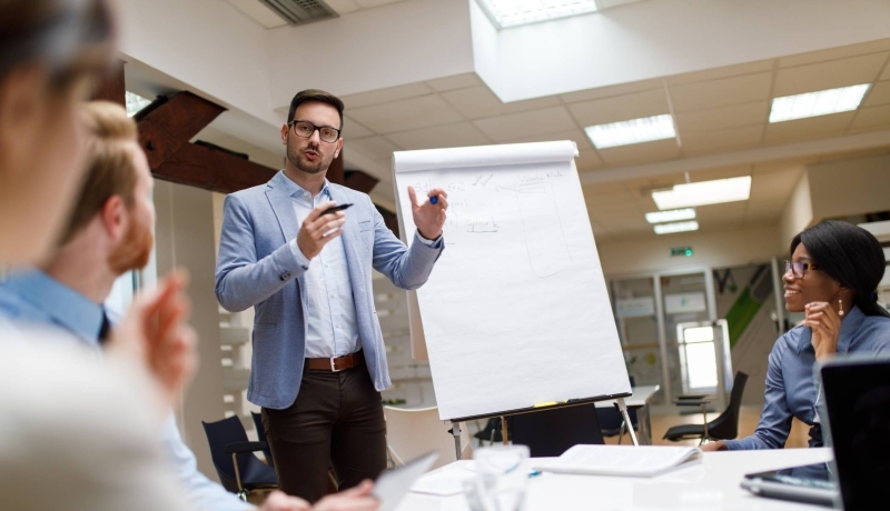 Praktijk docent van de post-hbo opleiding Sales Management tijdens college in gesprek met deelnemers op de HAN campus Arnhem.