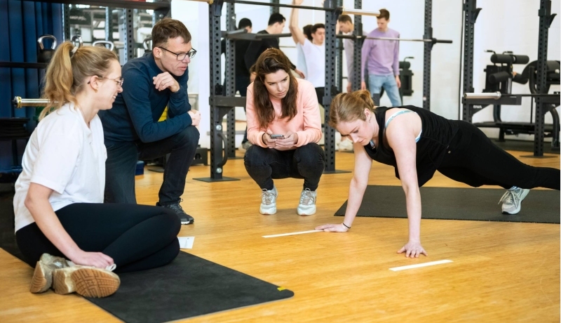 Docent en student sportfysiotherapie in de gymzaal
