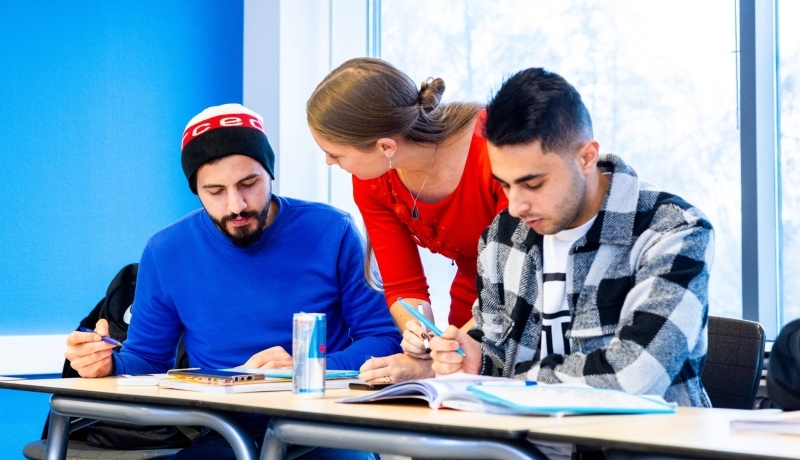 Docent en twee studenten in een klaslokaal