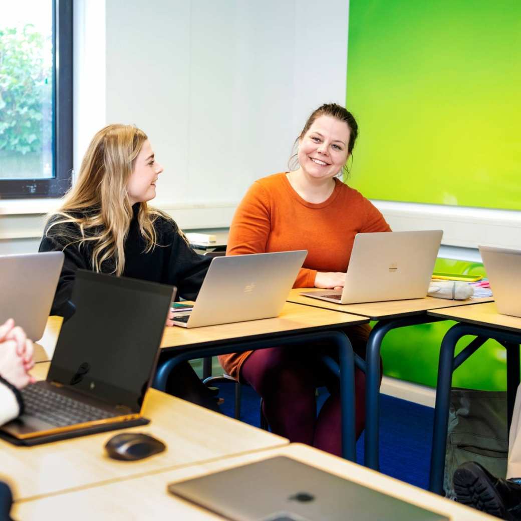 Student kijkt lachend medestudenten aan