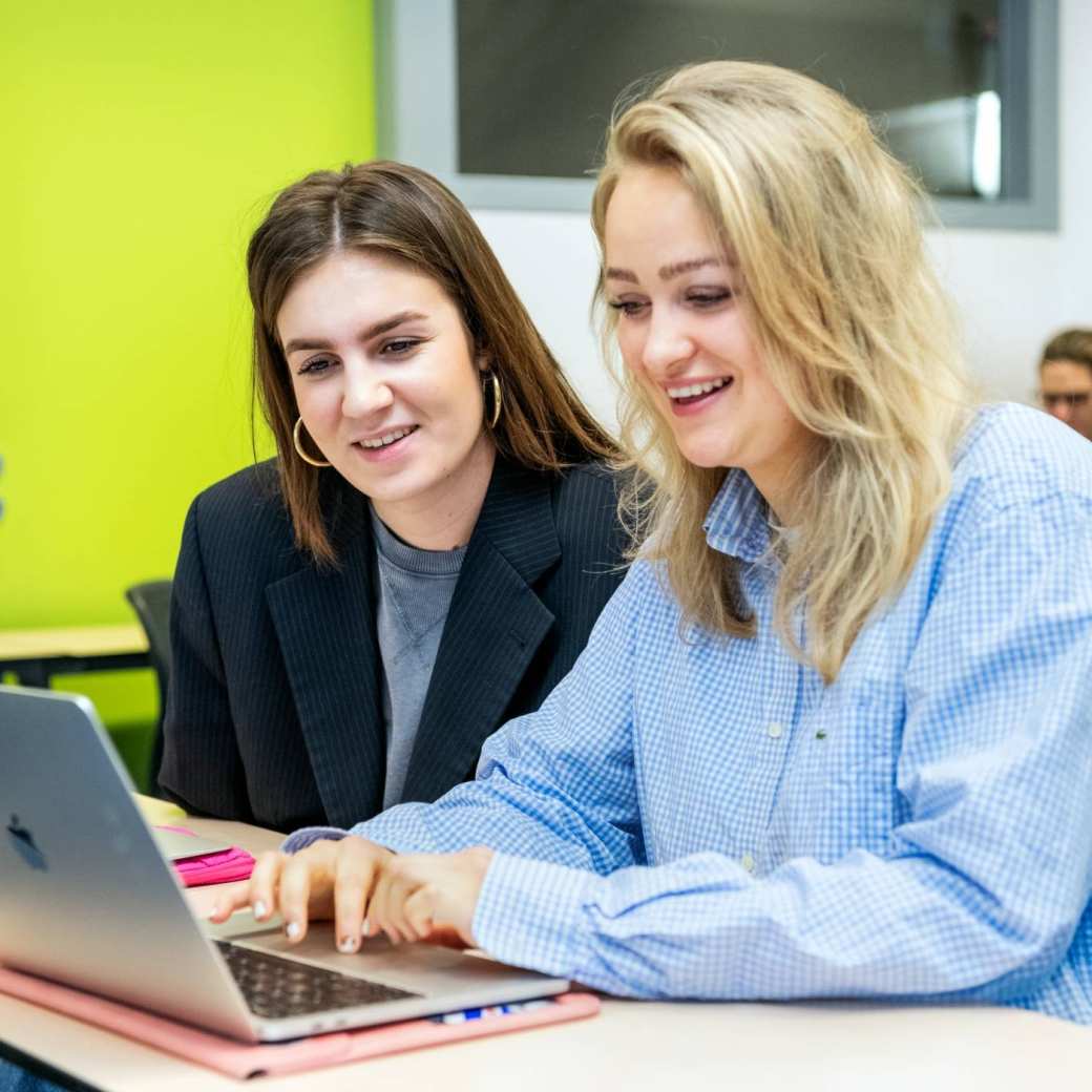 Ondernemerschap & Retail Management 2 studenten achter laptop