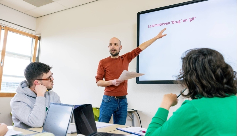 Leraar Nederlands staat voor de klas voor een whiteboard.