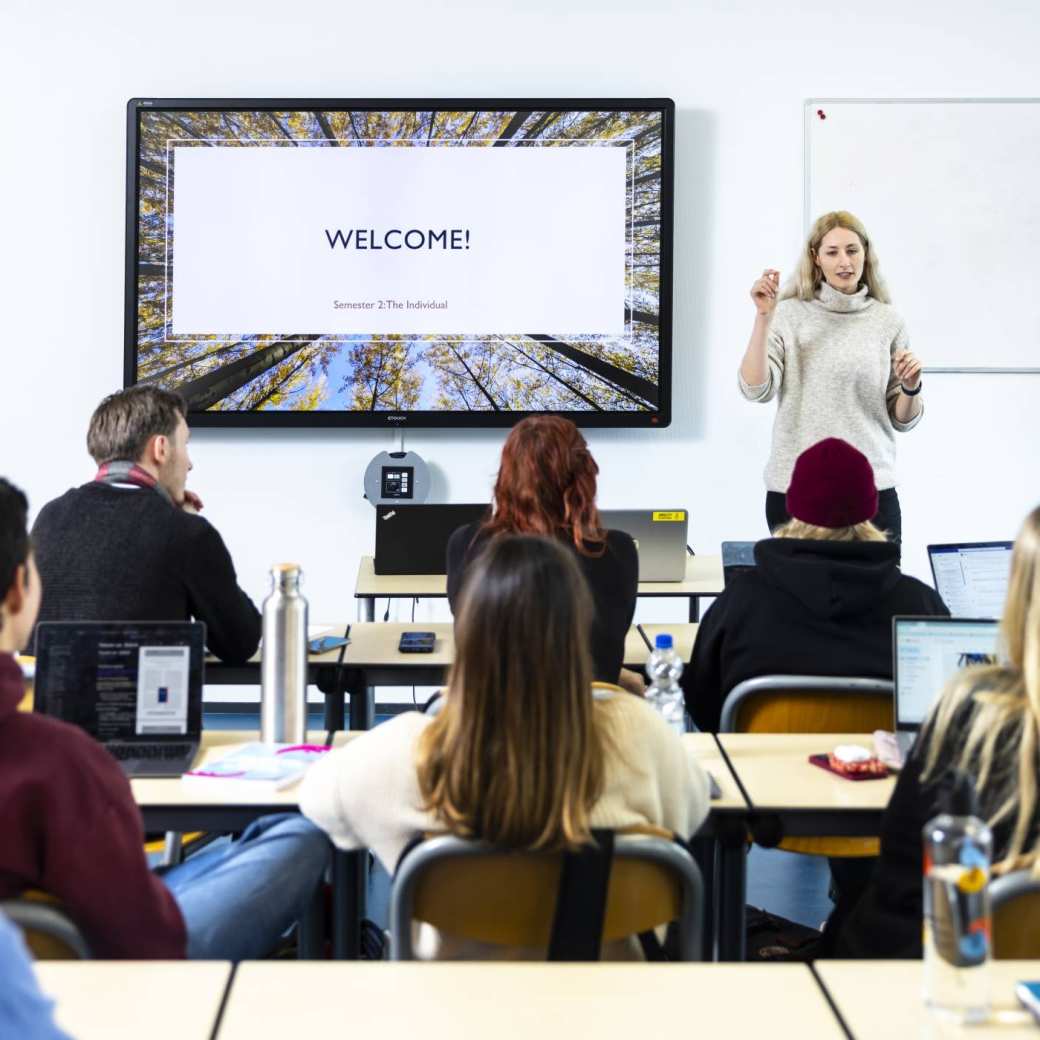 International Social Work. Klas college groep studenten en docent. digiboard op de achtergrond