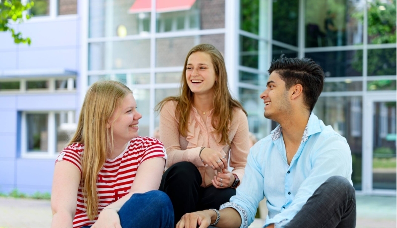 Drie studenten van hbo Bedrijfskunde buiten bij de HAN campus