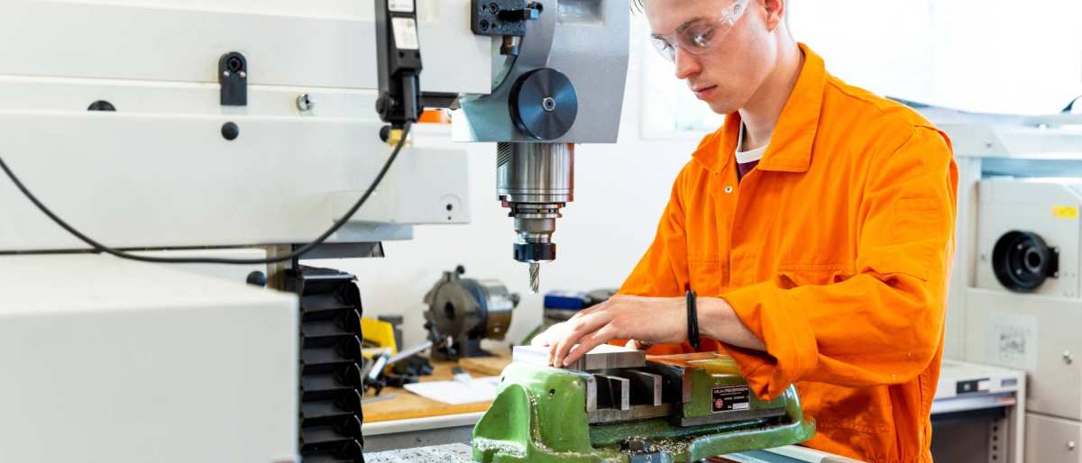 Mechanical Engineering - Werktuigbouwkunde - student working behind a machine in the lab