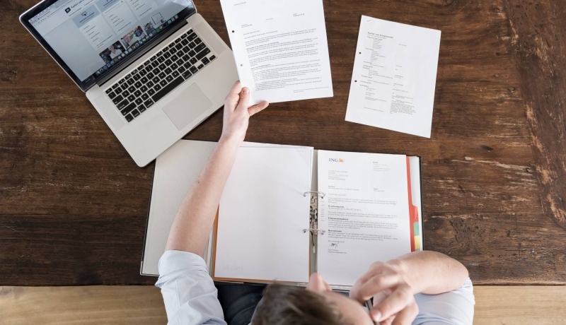 Man leest overheidsbrieven aan tafel