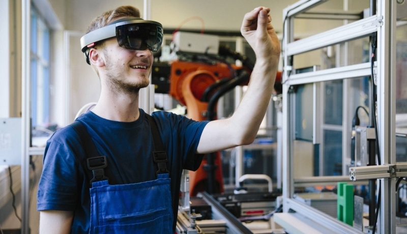 Man / student werkt met AR bril op. Virtual reality in een productieomgeving.