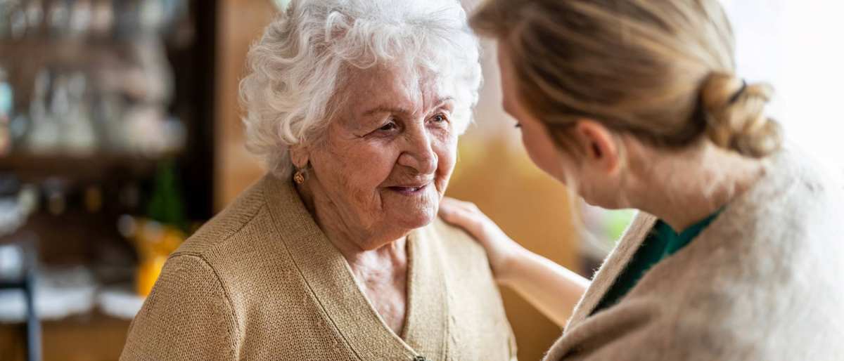 Verpleegkundige in gesprek met oudere vrouw