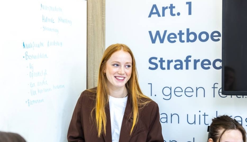 Student wijst iets aan het op het bord