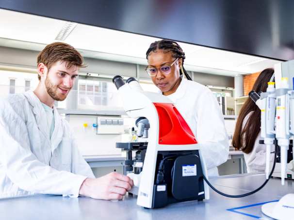 studenten aan het werk met een microscoop