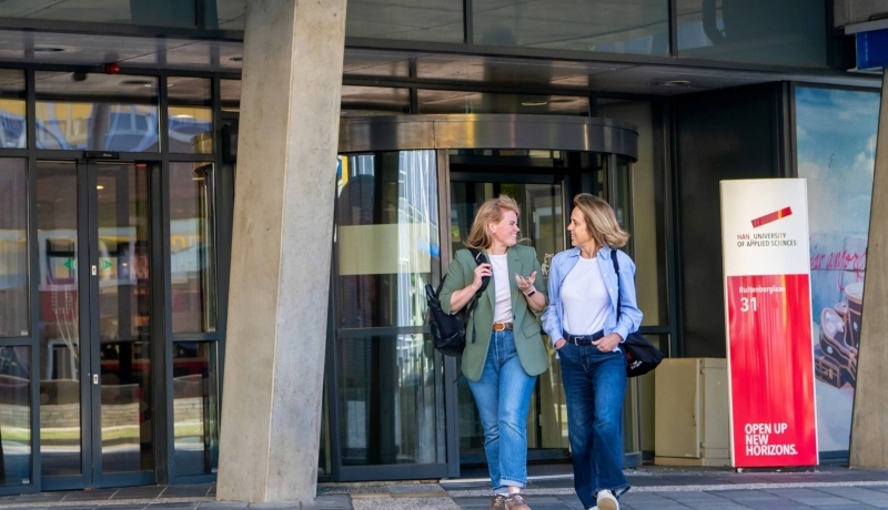 twee deelnemers van Middle Management lopen het HAN-gebouw uit