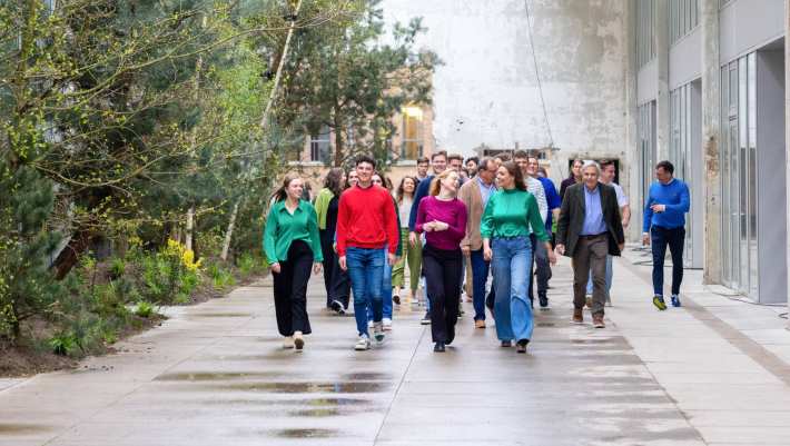 Groep studenten en docenten wandelt door IPKW met groen op de achtergrond. Fotografie Master Circulaire Economie voltijd.