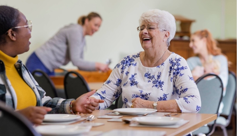 Lachende dame aan eettafel
