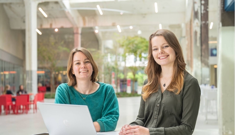 Twee studenten van de master Duurzaamheidstransities met een laptop aan een tafel