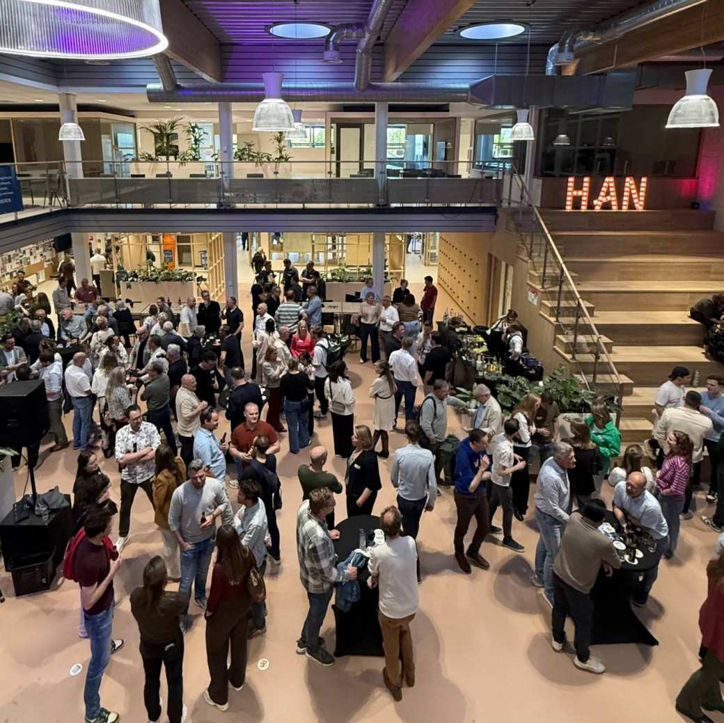 een zaal gevuld met mensen van de reünie van bovenaf gezien