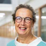 Portretfoto Marian de van der Schueren, brildragend, witte blouse, zeegroene trui