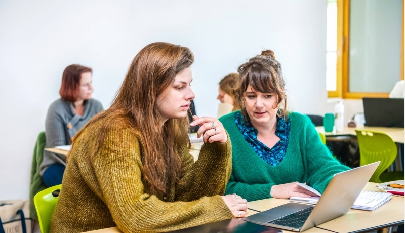 Twee studenten Leraar Engels werken samen op één laptop.