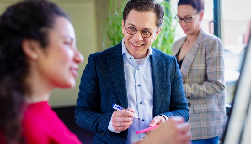 een deelnemer van IPMA D/C voor een bord met verschillende kleuren post-its